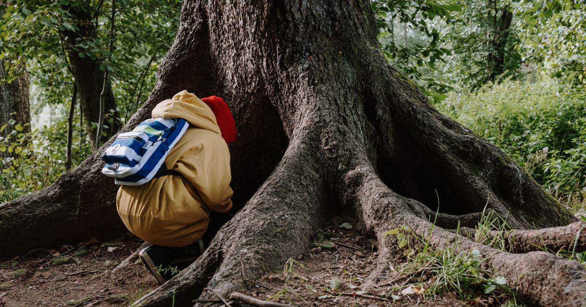 Person in brown jacket and blue denim jeans sitting on brown tree trunk by cottonbro on Pexels