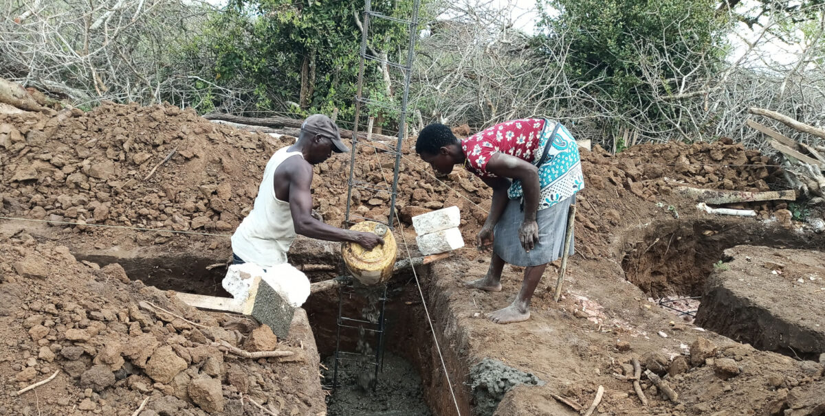 Furaha helping a builder with the concrete foundations