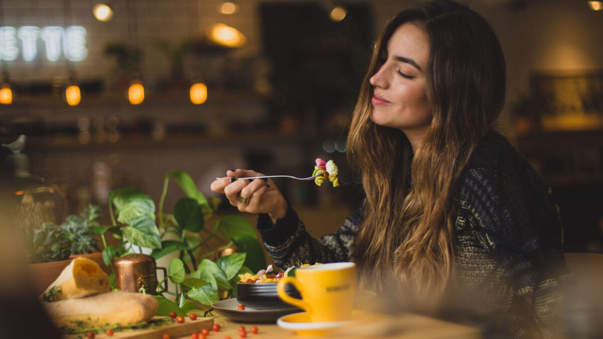 Woman holding fork in front of a table