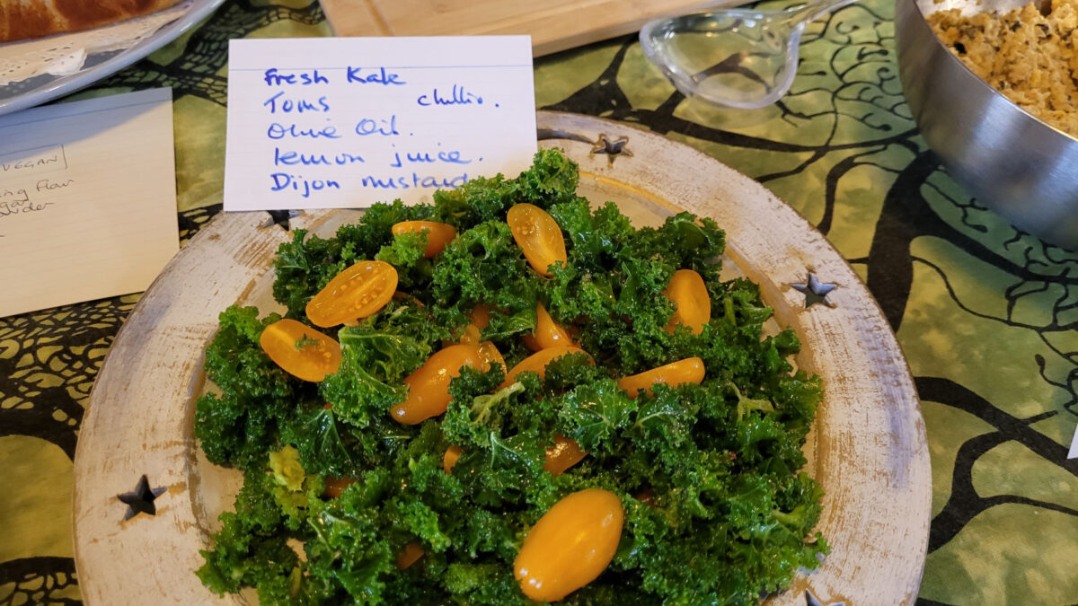 A dish of fresh kale and golden tomatoes