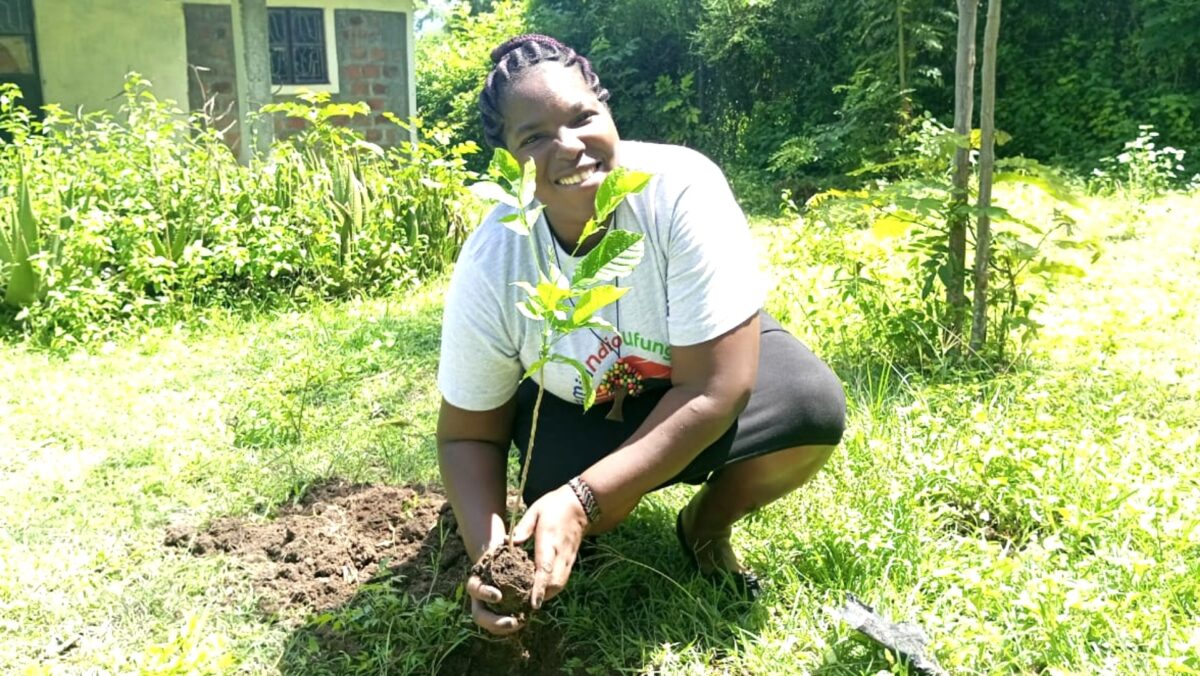 Joy planting a sapling on her shamba